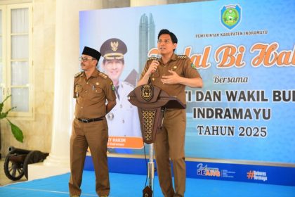 INDRAMAYU – Pemerintah Kabupaten Indramayu memanfaatkan momentum Halal Bihalal untuk mempererat tali silaturahmi sekaligus memperkuat sinergi antara pemerintah daerah dan jajaran pemerintahan desa. Acara tersebut digelar di Pendopo Kabupaten Indramayu, Selasa (29/4/2025), dan dihadiri oleh 309 Kuwu, 8 Lurah, serta para Camat se-Kabupaten Indramayu. Dalam sambutannya, Bupati Indramayu Lucky Hakim menyampaikan permohonan maaf lahir dan batin, sekaligus mengapresiasi kehadiran para pemimpin wilayah. Ia menegaskan bahwa Kuwu memiliki peran strategis sebagai mitra kerja pemerintah daerah dalam menyukseskan program-program pembangunan di tingkat desa. “Saya diamanahkan oleh masyarakat menjadi bupati, dan saya memandang Kuwu sebagai mitra kerja. Koordinasi dengan Camat adalah kunci keberhasilan dalam mengelola desa,” ujar Bupati Lucky. Salah satu program yang disoroti adalah rencana pembentukan koperasi desa yang akan dibiayai melalui Pendapatan Asli Desa (PADes). Bupati menekankan pentingnya sinkronisasi antara program desa dan kebijakan pusat agar pembangunan berjalan efektif. Ia juga mengimbau agar para Kuwu menjaga transparansi dan akuntabilitas dalam pelaksanaan tugas, serta aktif berkoordinasi jika menemui aturan atau kebijakan yang belum jelas. Wakil Bupati Indramayu, Syaefudin, turut memberikan sambutan dan menyampaikan apresiasi atas kehadiran seluruh peserta. Ia mengingatkan pentingnya peran Camat sebagai pembina bagi Kuwu dan menekankan pengelolaan sampah sebagai salah satu fokus utama Pemkab Indramayu. “Pengelolaan sampah harus menjadi perhatian bersama karena ini menyangkut kenyamanan dan keamanan lingkungan. Kami juga mengajak APDESI untuk terus mengaktifkan dan mereaktivasi program-program pembangunan,” ujar Syaefudin. Ketua APDESI Indramayu yang juga Kuwu Desa Kebulen, Tarkani, mengungkapkan rasa terima kasih atas perhatian yang diberikan Pemkab kepada para Kuwu. Ia menyatakan komitmen penuh untuk mendukung program-program daerah, termasuk pengelolaan sampah dan pembentukan koperasi desa. “Kami siap mendukung penuh. Namun kami juga berharap agar fasilitas seperti armada pengangkut sampah bisa segera dipenuhi agar tidak terjadi penumpukan di TPS,” kata Tarkani. Acara ditutup dengan sesi dialog terbuka, memberikan ruang bagi para Kuwu dan Lurah untuk menyampaikan langsung aspirasi, keluhan, serta saran kepada Bupati dan Wakil Bupati. Momen ini mencerminkan komitmen bersama dalam membangun Indramayu yang lebih baik melalui komunikasi yang terbuka dan inklusif.